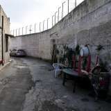 Via Giuseppe Colapietro, strada circondata da un alto muro di cemento  